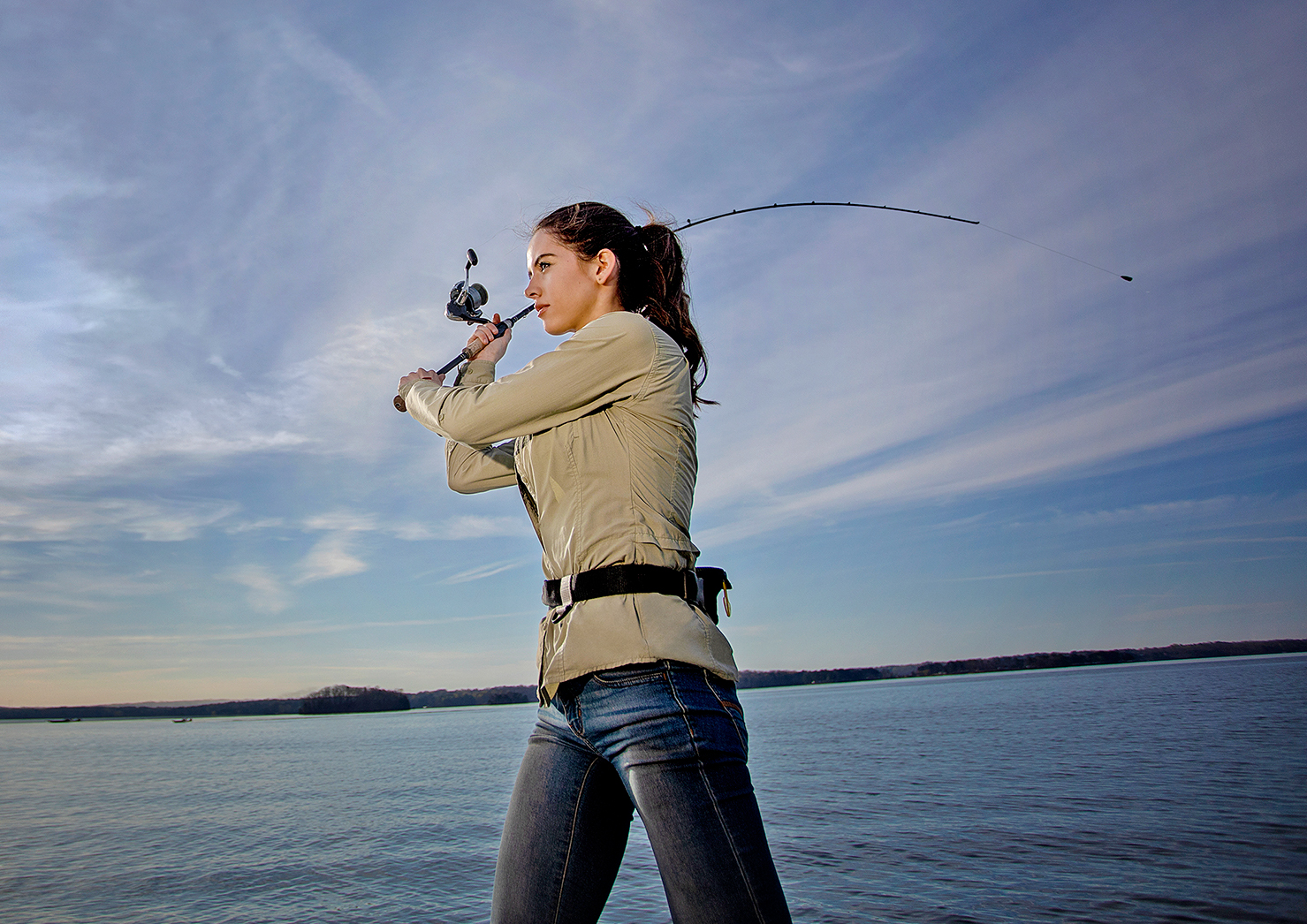 Woman On A Boat Casting A Fishing Rod