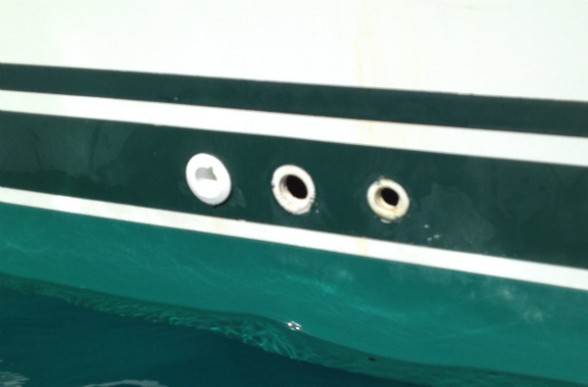 Two of these three plastic through-hull drain fittings have failed, and the hoses have fallen inside the boat.